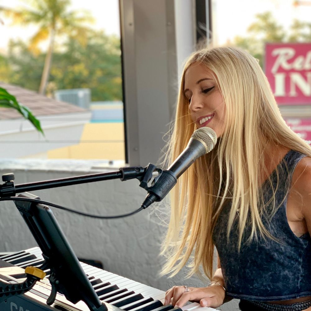Joanna singing at a waterfront venue